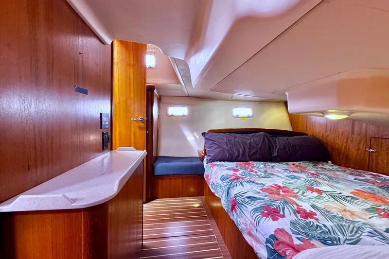 Yacht Photos Pics Cozy cabin interior of 2006 Hunter 38 sailboat with floral bedding and wooden finishes.