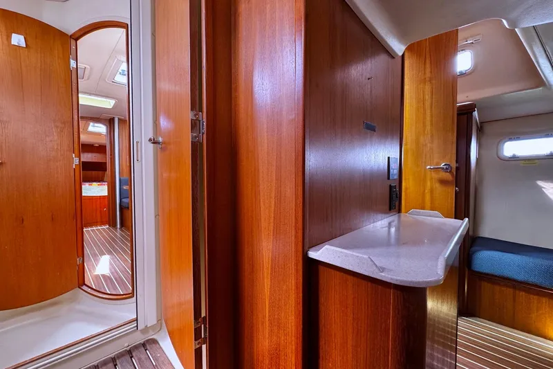  Yacht Photos Pics Interior of a 2006 Hunter 38 sailboat, featuring wooden cabinetry and cozy sleeping quarters.