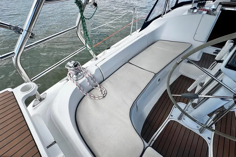  Yacht Photos Pics 2006 Hunter 38 sailboat cockpit with cushioned seating and steering wheel, overlooking water.