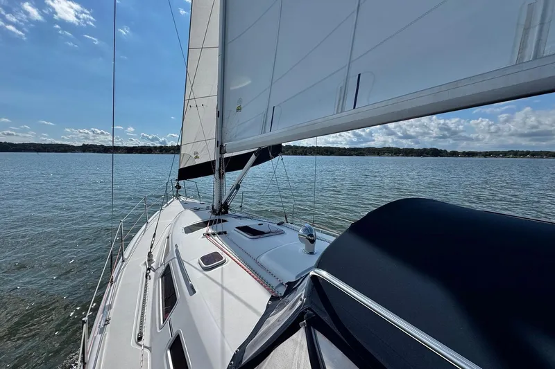  Yacht Photos Pics Sailing on a 2006 Hunter 38 yacht under clear skies on a serene lake.