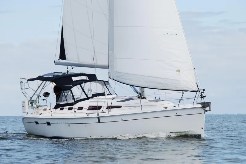  Yacht Photos Pics 2006 Hunter 38 sailboat cruising on open water with full sails.