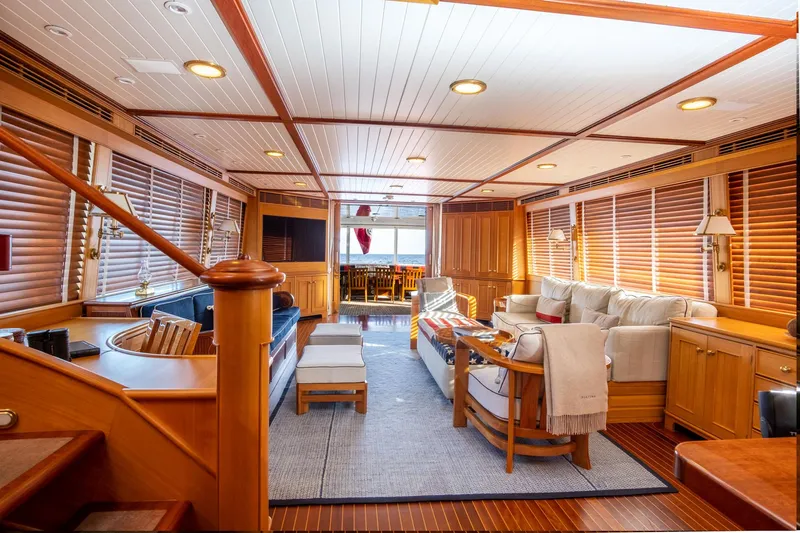 Fortuna Yacht Photos Pics Luxurious interior of a 1999 Palmer Johnson motor yacht with elegant wood paneling and cozy seating.