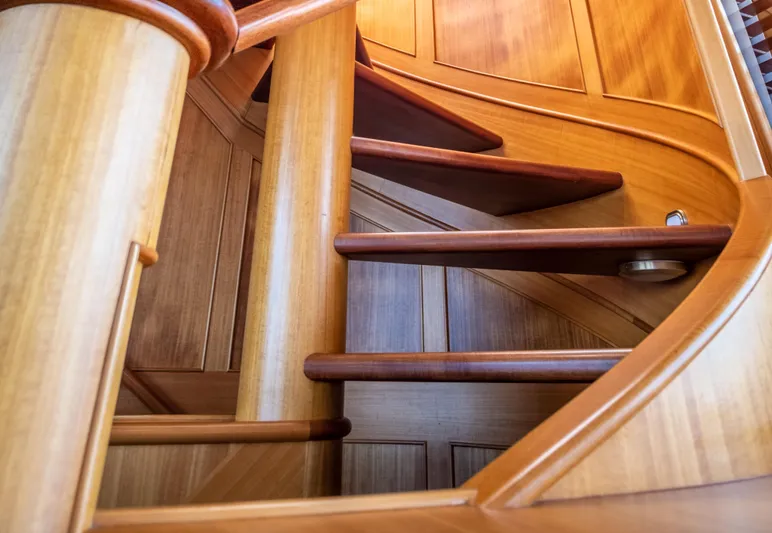 Fortuna Yacht Photos Pics Wooden staircase inside a 1999 Palmer Johnson motor yacht, showcasing elegant craftsmanship.