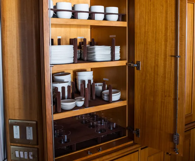 Fortuna Yacht Photos Pics Luxurious wooden cabinet with neatly organized dishes on a 1999 Palmer Johnson Motor Yacht.