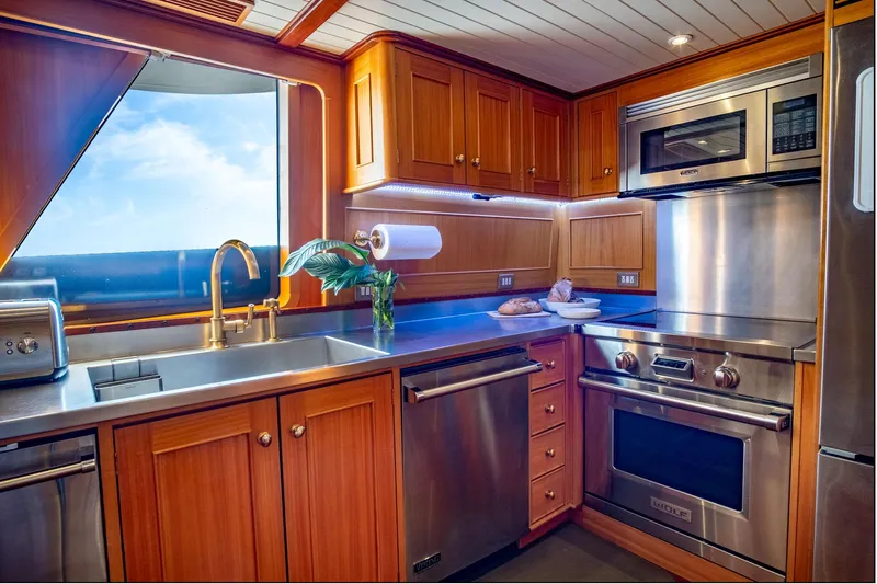 Fortuna Yacht Photos Pics Luxurious kitchen in 1999 Palmer Johnson motor yacht with stainless steel appliances and wooden cabinetry.