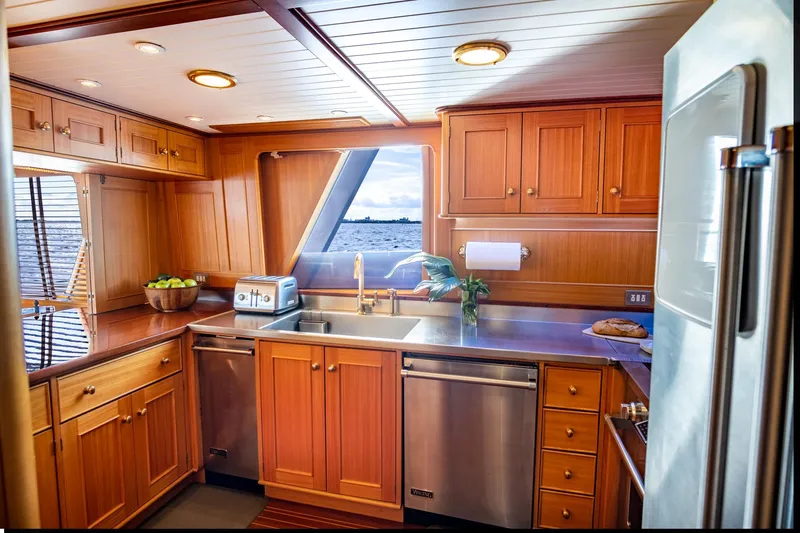 Fortuna Yacht Photos Pics Luxurious 1999 Palmer Johnson motor yacht kitchen with wooden cabinetry and modern appliances.