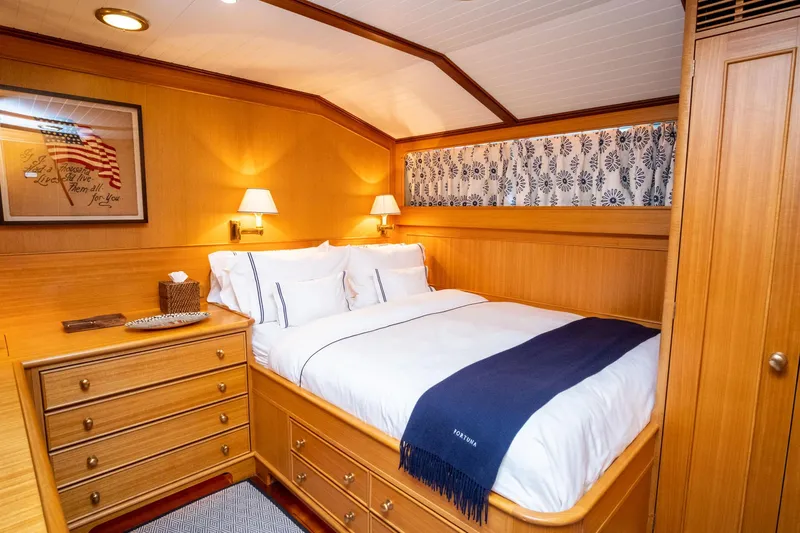Fortuna Yacht Photos Pics Cozy bedroom in 1999 Palmer Johnson motor yacht with wooden decor and elegant bedding.