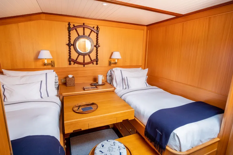 Fortuna Yacht Photos Pics Luxurious twin cabin on 1999 Palmer Johnson motor yacht with nautical decor and wooden furnishings.