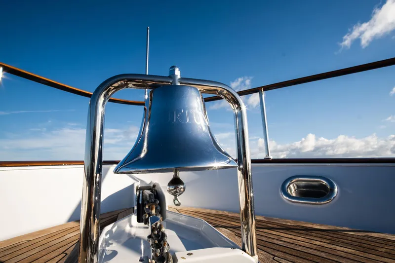 Fortuna Yacht Photos Pics Shiny bell on 1999 Palmer Johnson motor yacht deck under clear blue sky.