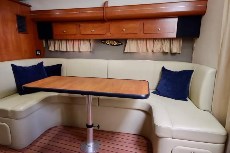 Pura Vida Yacht Photos Pics 2006 Rinker 360 Express Cruiser interior with beige seating and wooden table.