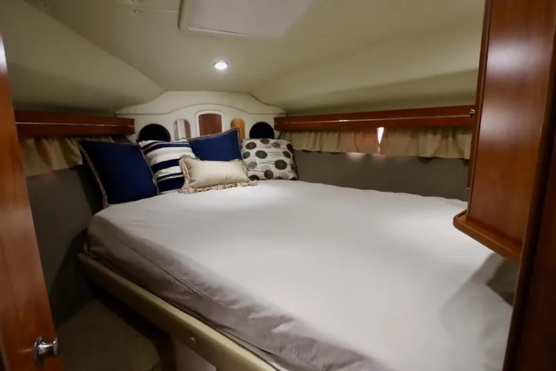 Pura Vida Yacht Photos Pics Cozy cabin interior of 2006 Rinker 360 Express Cruiser with plush bedding and pillows.