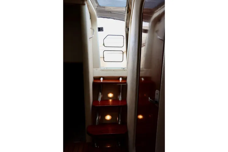 Pura Vida Yacht Photos Pics Interior stairs of 2006 Rinker 360 Express Cruiser with wooden steps and lighting.