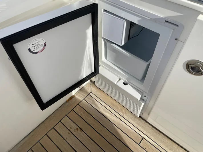  Yacht Photos Pics Open mini fridge on 2012 Princess 72 Motor Yacht with wooden deck flooring.
