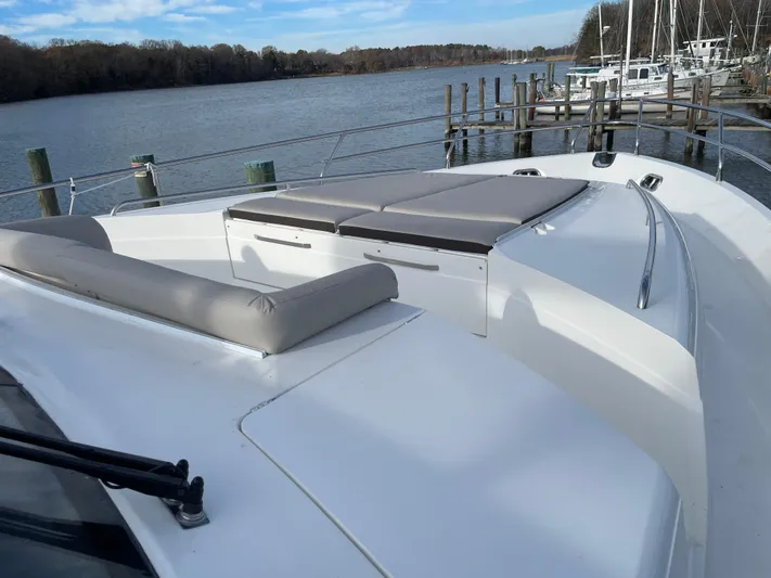  Yacht Photos Pics 2012 Princess 72 Motor Yacht with spacious deck and seating, docked by a serene river.