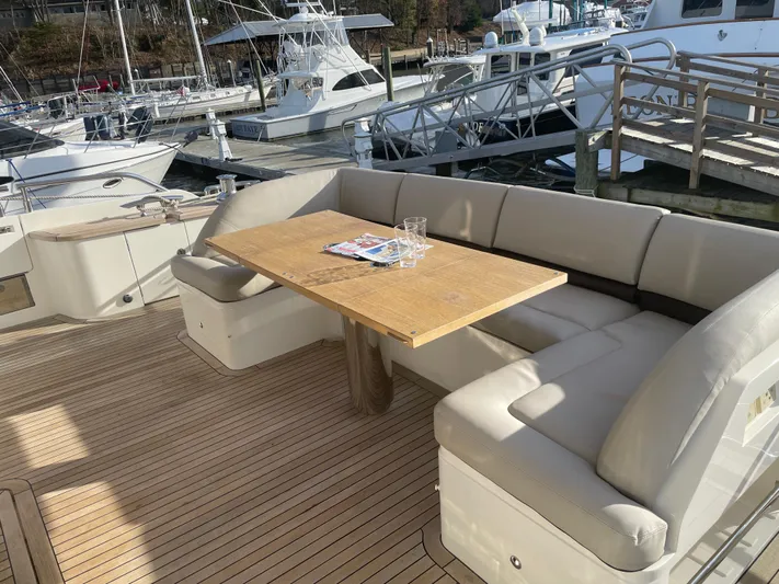  Yacht Photos Pics Luxurious seating area on 2012 Princess 72 Motor Yacht with wooden table and marina view.