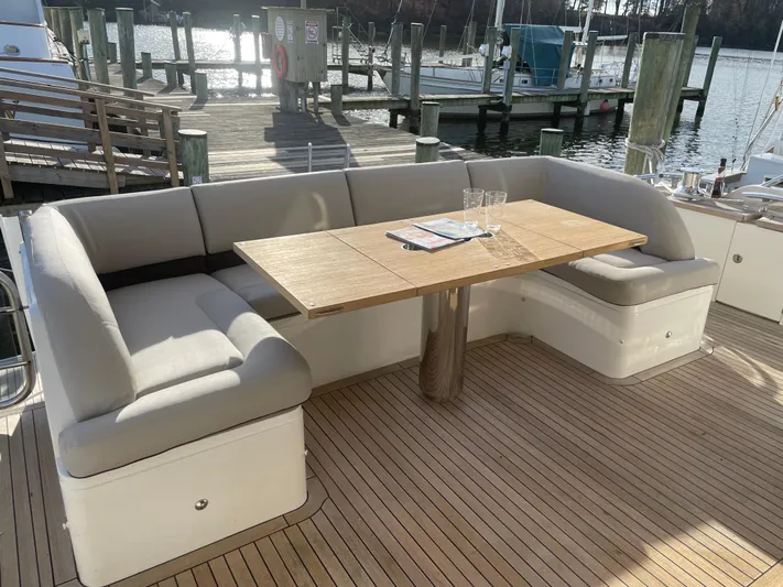  Yacht Photos Pics Luxurious seating area on 2012 Princess 72 Motor Yacht with wooden table and waterfront view.