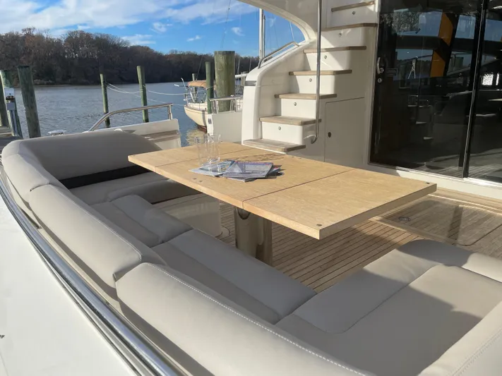  Yacht Photos Pics Luxurious seating area on 2012 Princess 72 Motor Yacht with wooden table and scenic water view.