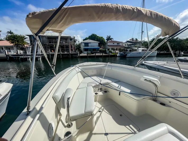  Yacht Photos Pics 2016 Sailfish 320CC boat with canopy, docked in a scenic waterfront area.