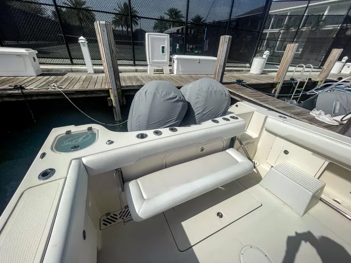  Yacht Photos Pics 2016 Sailfish 320CC boat interior at dock, featuring seating and covered engines.
