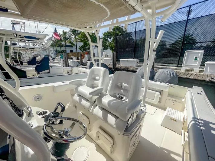  Yacht Photos Pics 2016 Sailfish 320CC boat interior with dual white captain chairs and steering wheel.