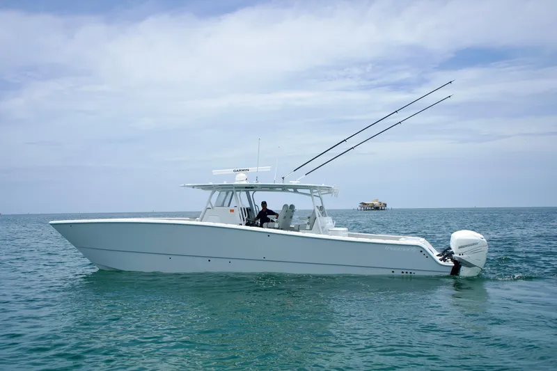  Yacht Photos Pics 2022 Freeman 42 LR boat on calm ocean waters, equipped with fishing rods and outboard motors.