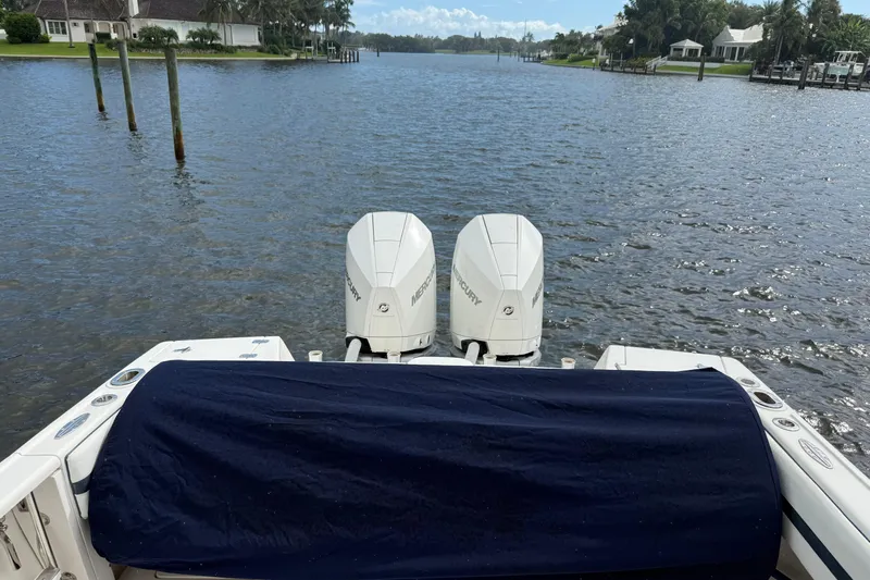  Yacht Photos Pics Rear view of 2009 Intrepid 323 boat with twin Mercury engines on a calm waterway.