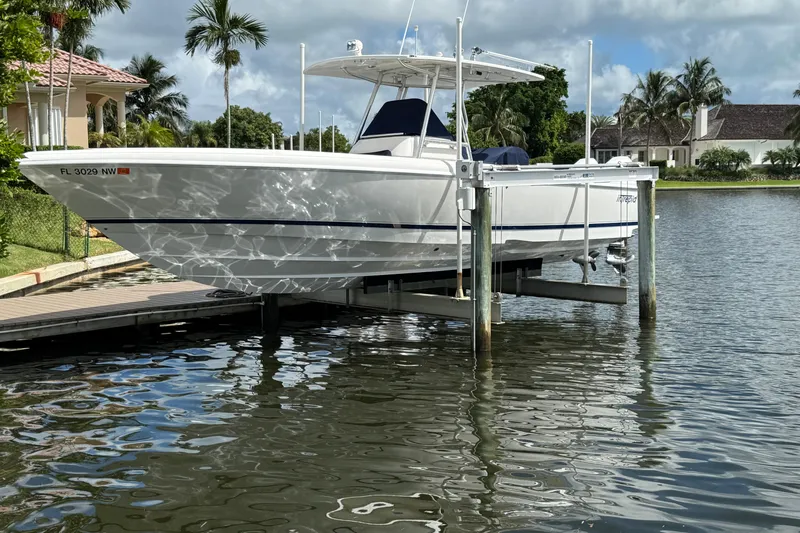  Yacht Photos Pics 2009 Intrepid 323 boat docked on a lift by a waterfront home.