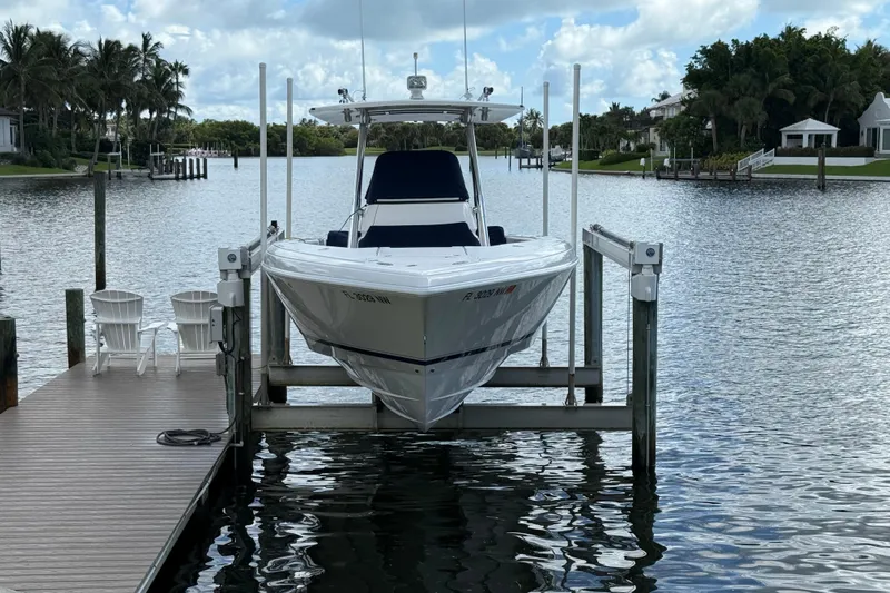  Yacht Photos Pics Intrepid 323 boat from 2009 on a lift at a scenic waterfront dock.