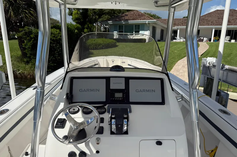  Yacht Photos Pics 2009 Intrepid 323 boat dashboard with Garmin navigation system, docked near a waterfront home.