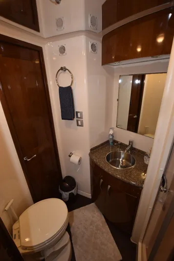 Seawood Yacht Photos Pics 2007 Carver 52 Voyager yacht bathroom with sink, toilet, and wooden cabinetry.
