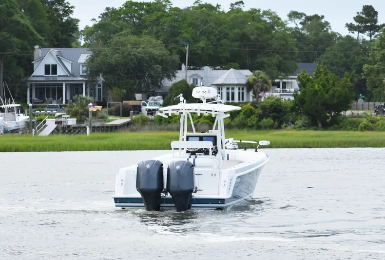  Yacht Photos Pics 2007 Contender 33 Tournament boat cruising near waterfront homes.