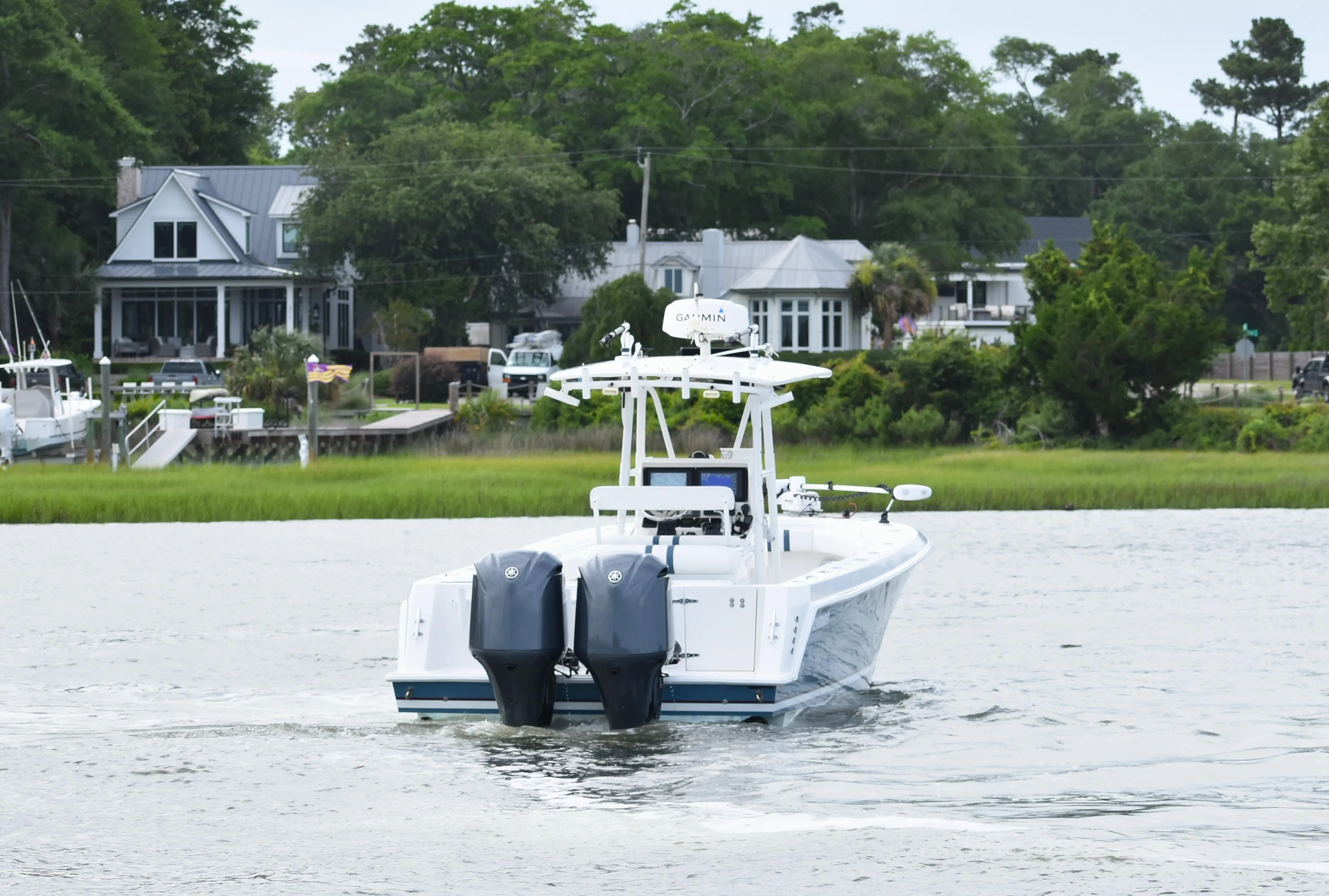 2007 Contender 33 Tournament boat cruising near waterfront homes.