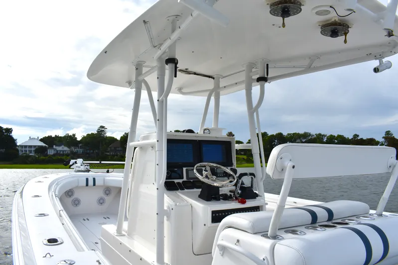  Yacht Photos Pics 2007 Contender 33 Tournament boat interior with helm, seating, and electronics on a calm waterway.