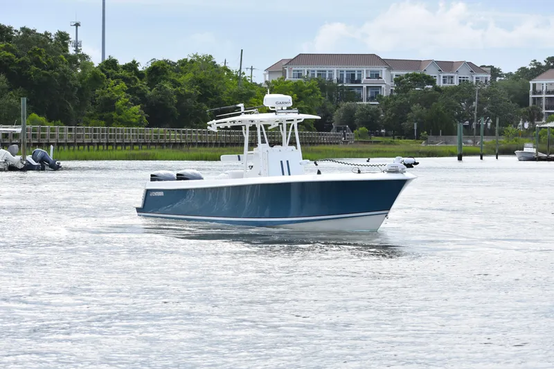  Yacht Photos Pics 2007 Contender 33 Tournament boat on water, with scenic background of trees and buildings.