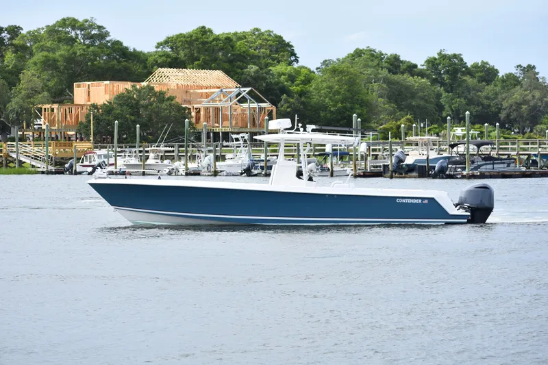  Yacht Photos Pics 2007 Contender 33 Tournament boat cruising on a calm river near a marina.