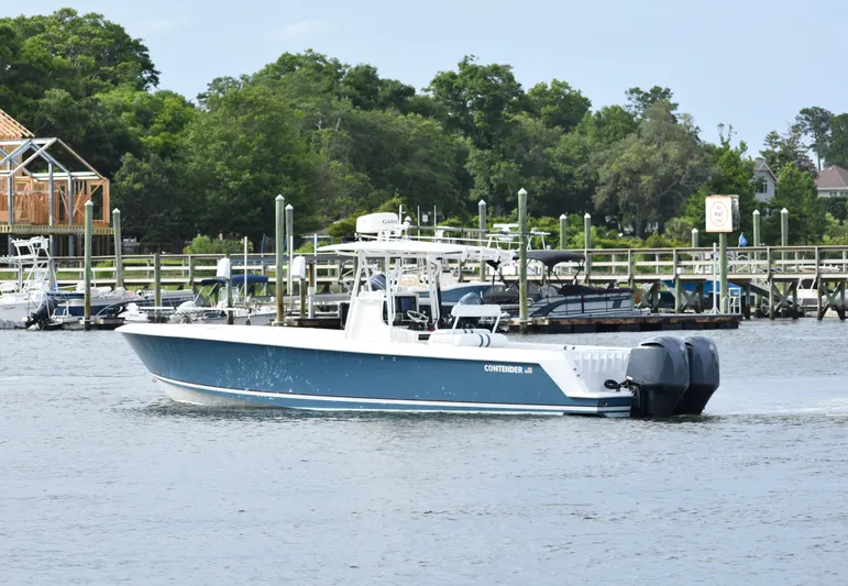  Yacht Photos Pics 2007 Contender 33 Tournament boat cruising on a calm river near a marina.