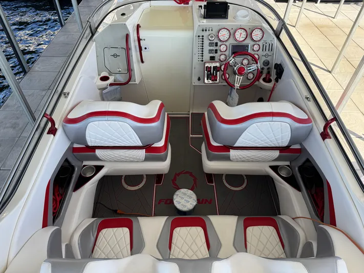  Yacht Photos Pics 2008 Fountain 38 Lightning boat interior with red and white seating, dashboard, and steering wheel.
