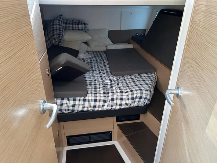  Yacht Photos Pics Cozy cabin interior of 2022 Hanse 510 yacht with plaid bedding and wooden finishes.