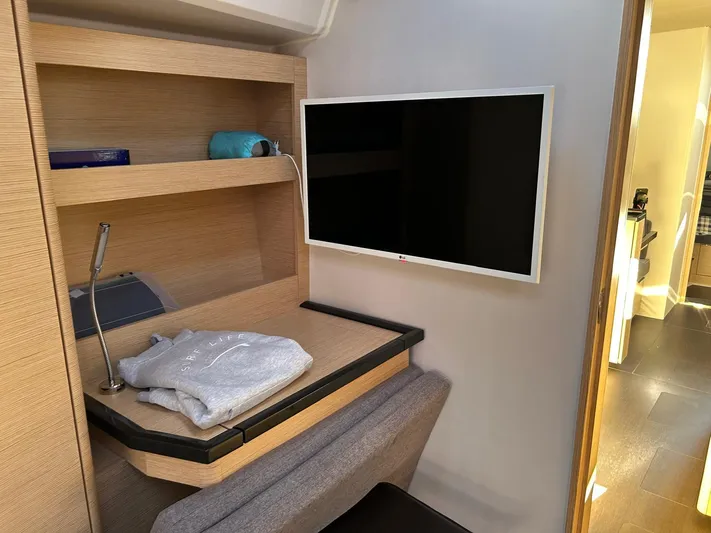  Yacht Photos Pics Interior of 2022 Hanse 510 yacht with TV, desk, and shelves.