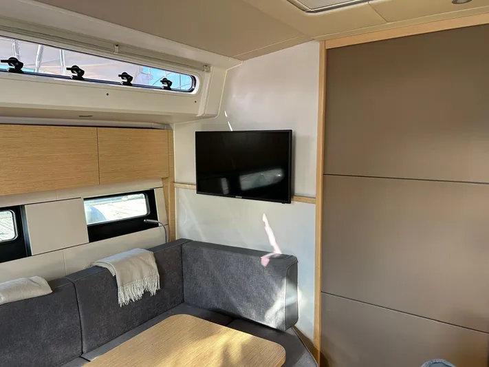  Yacht Photos Pics Interior of 2022 Hanse 510 yacht with modern seating, TV, and window.