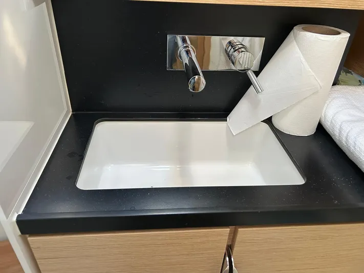  Yacht Photos Pics Modern sink with black countertop and paper towel holder on a Hanse 510 yacht, 2022 model.