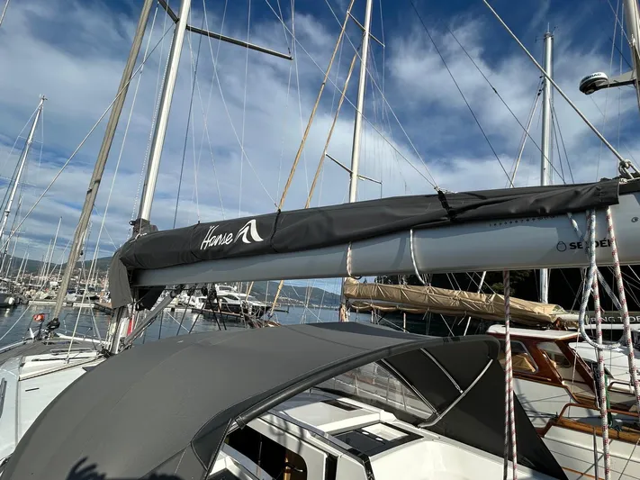  Yacht Photos Pics 2022 Hanse 510 sailboat with covered boom, docked at marina under clear sky.