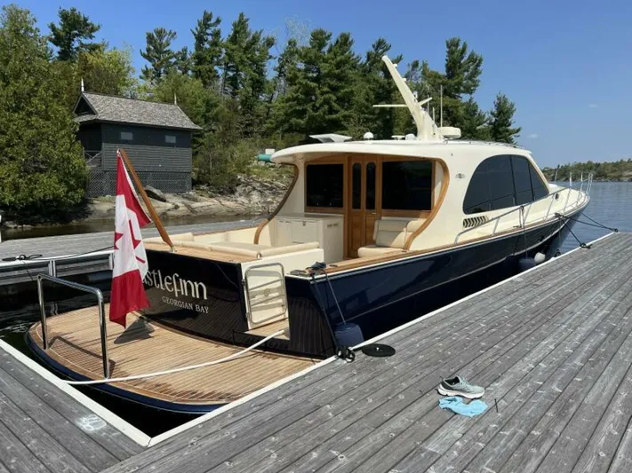Castlefinn Yacht Photos Pics 2018 Palm Beach Motor Yachts PB55 docked, Canadian flag, serene lakeside setting.