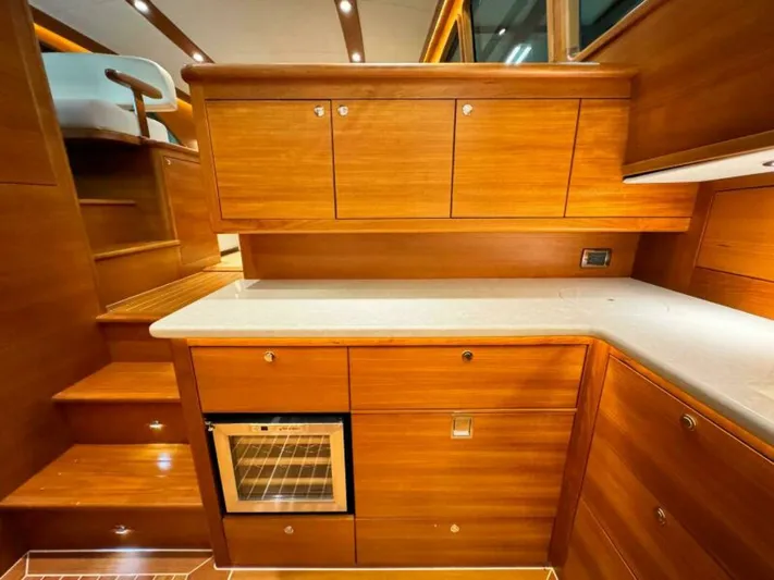 Castlefinn Yacht Photos Pics 2018 Palm Beach Motor Yachts PB55 interior with wooden cabinetry and compact kitchen area.