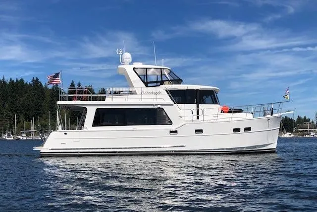 Boondoggle Yacht Photos Pics 2021 North Pacific 49 Pilothouse yacht on calm water, with clear blue sky.