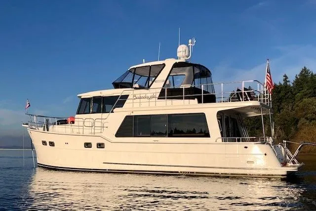 Boondoggle Yacht Photos Pics 2021 North Pacific 49 Pilothouse yacht on calm water, clear sky background.
