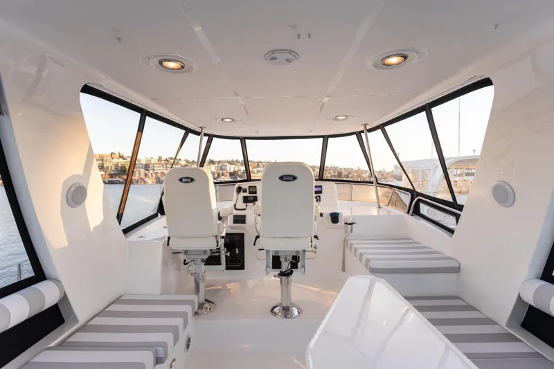 Boondoggle Yacht Photos Pics Interior of 2021 North Pacific 49 Pilothouse with modern seating and panoramic windows.