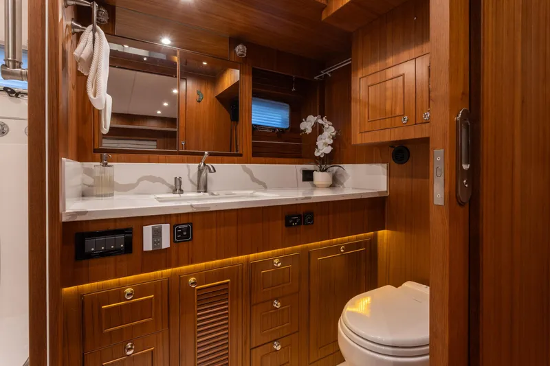 Boondoggle Yacht Photos Pics Luxurious wooden bathroom interior of 2021 North Pacific 49 Pilothouse yacht.