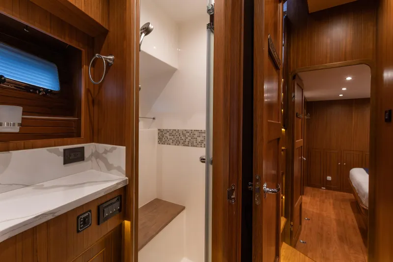 Boondoggle Yacht Photos Pics Luxurious 2021 North Pacific 49 Pilothouse interior with wood finish and modern bathroom.