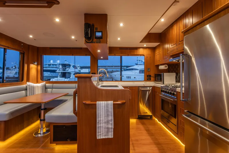 Boondoggle Yacht Photos Pics Luxurious 2021 North Pacific 49 Pilothouse interior with modern kitchen and dining area.